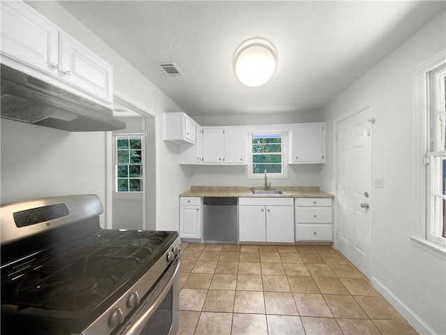 kitchen with stainless steel appliances, white cabinetry, light tile patterned flooring, and sink