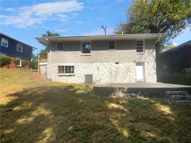 rear view of property featuring a lawn, a patio, and central AC