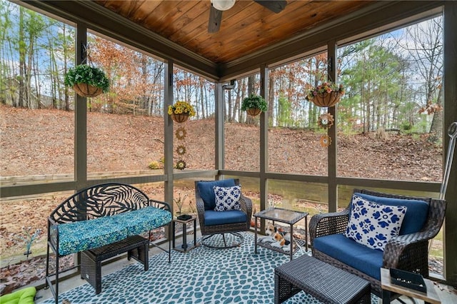 sunroom / solarium featuring ceiling fan, a wealth of natural light, and wood ceiling