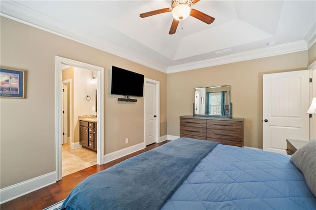 bedroom featuring ensuite bath, light hardwood / wood-style floors, crown molding, ceiling fan, and a raised ceiling