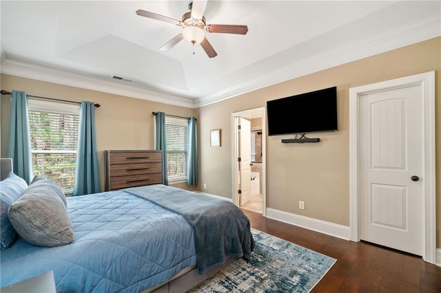 bedroom with multiple windows, dark wood-type flooring, crown molding, and a tray ceiling