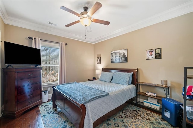 bedroom with dark wood-type flooring, crown molding, and ceiling fan