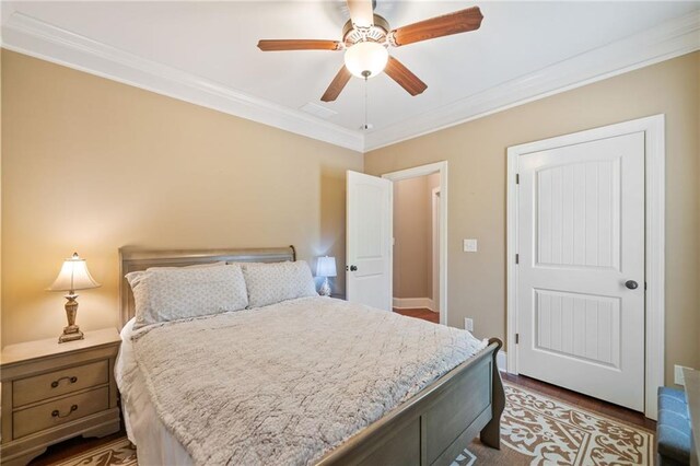 bedroom with hardwood / wood-style flooring, ornamental molding, and ceiling fan