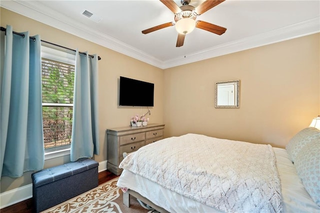 bedroom featuring dark hardwood / wood-style flooring, ceiling fan, and crown molding