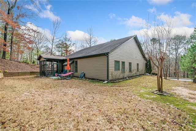 view of home's exterior featuring a sunroom and a lawn