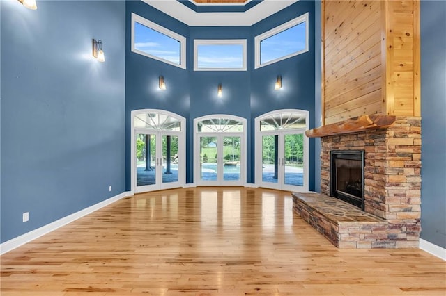 1580 Loving Rd, Morganton, GA 30560 - unfurnished living room featuring baseboards, a stone fireplace, a wealth of natural light, and wood finished floors