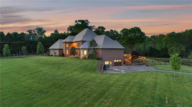 1580 Loving Rd, Morganton, GA 30560 - back of house at dusk featuring a lawn, driveway, and a garage