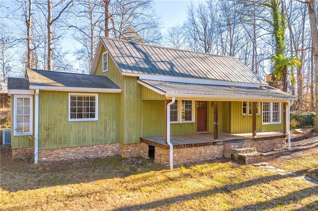 view of front of home featuring a front yard, covered porch, and cooling unit