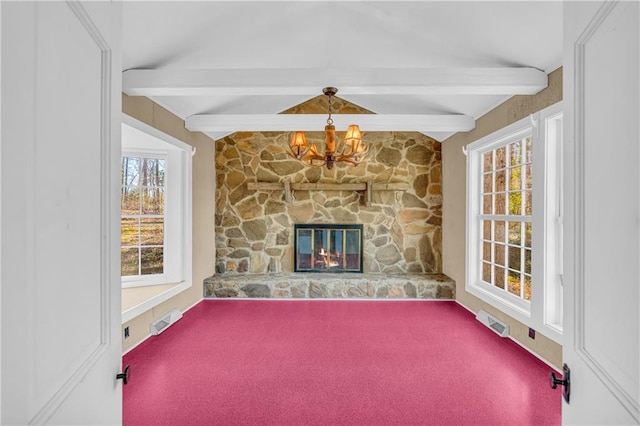 unfurnished living room with carpet, a notable chandelier, beamed ceiling, and a fireplace