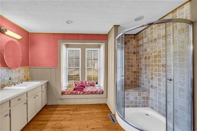 bathroom featuring a shower with shower door, vanity, and hardwood / wood-style flooring