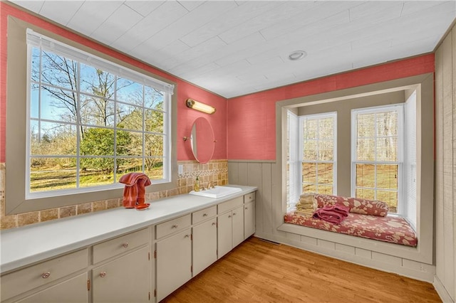 interior space featuring light hardwood / wood-style floors, sink, and white cabinets