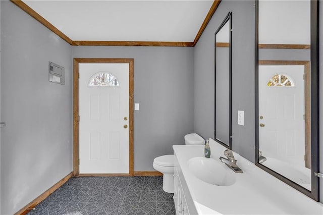 bathroom featuring toilet, vanity, and ornamental molding