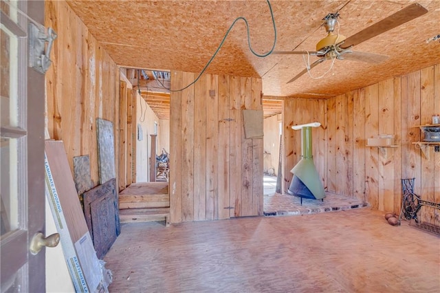 miscellaneous room featuring ceiling fan and wood walls