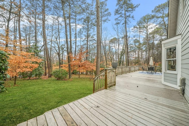 wooden terrace with outdoor dining area and a yard