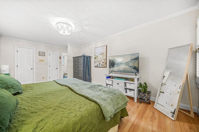 bedroom with baseboards, light wood finished floors, and ornamental molding