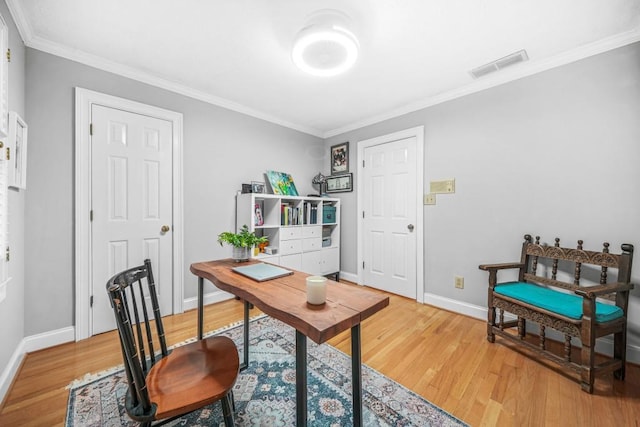 home office featuring visible vents, baseboards, crown molding, and light wood finished floors