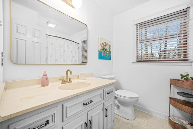 bathroom featuring toilet, vanity, a shower with shower curtain, and baseboards