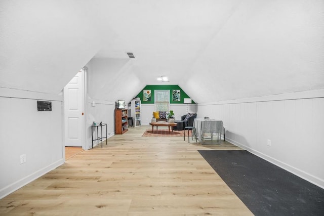 additional living space with vaulted ceiling, visible vents, and wood finished floors