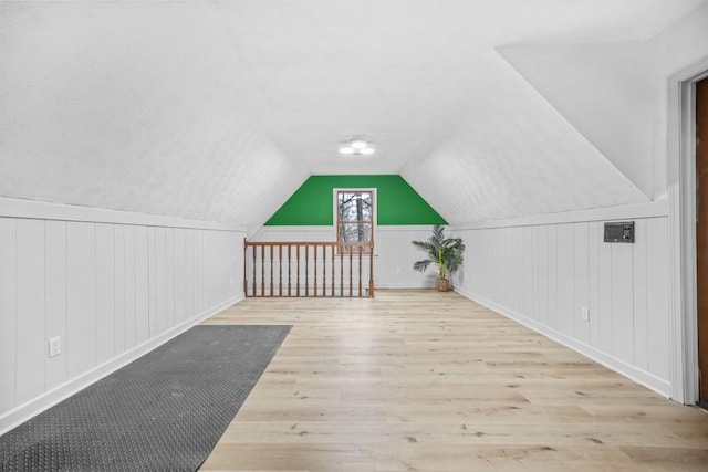 additional living space featuring vaulted ceiling and wood finished floors