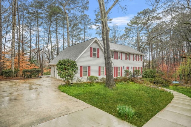 view of front of house featuring roof with shingles and concrete driveway