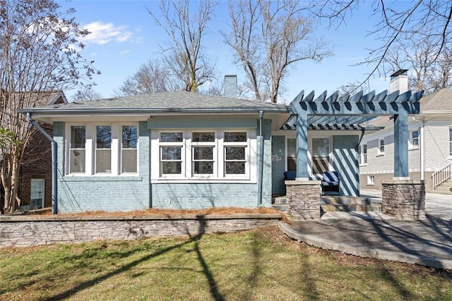 exterior space with brick siding, a chimney, and a pergola