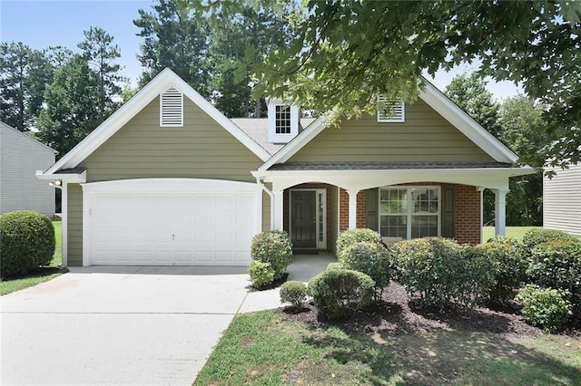 view of front of house featuring roof with shingles, covered porch, concrete driveway, a garage, and brick siding