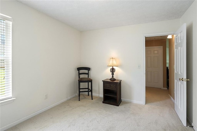 carpeted spare room with plenty of natural light, baseboards, and a textured ceiling