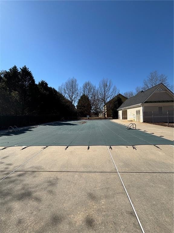 community pool with a patio and fence