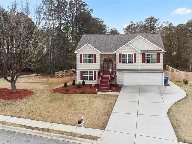 raised ranch with a garage, a front yard, and french doors