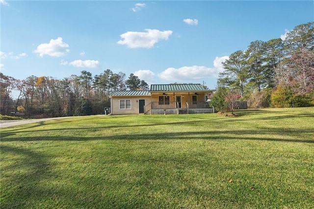 view of front of property featuring a standing seam roof, metal roof, a front lawn, and a porch