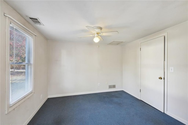 unfurnished room featuring baseboards, dark carpet, visible vents, and attic access