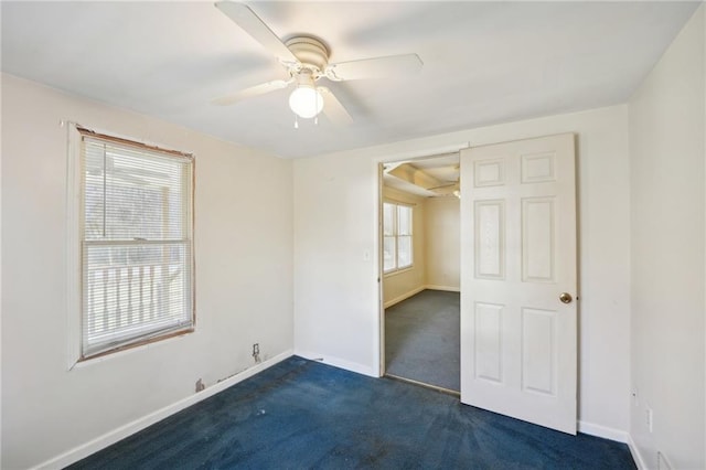 unfurnished bedroom with dark carpet, baseboards, and ceiling fan