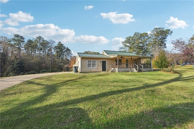 view of front of home featuring ceiling fan, metal roof, a standing seam roof, a porch, and a front yard