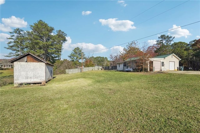 view of yard featuring a garage and an outbuilding