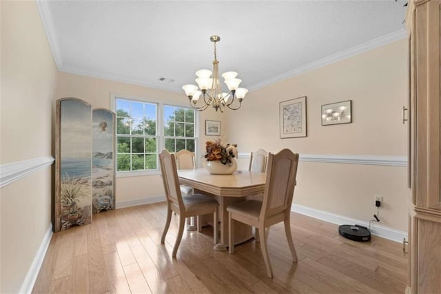 dining room with light hardwood / wood-style flooring, an inviting chandelier, and crown molding