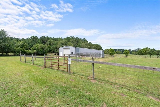 view of yard featuring an outbuilding, a rural view, and a garage