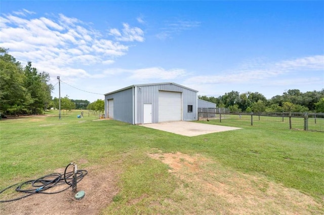 view of yard featuring a rural view, a garage, and an outdoor structure