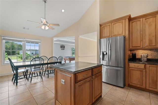 kitchen featuring vaulted ceiling, light tile patterned floors, billiards, stainless steel fridge with ice dispenser, and a kitchen island