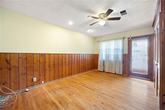 1191 S Burnt Hickory Rd, Douglasville, GA 30134 - empty room with a wainscoted wall, a textured ceiling, wood finished floors, wooden walls, and a ceiling fan