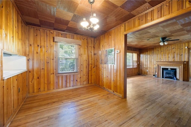 1191 S Burnt Hickory Rd, Douglasville, GA 30134 - unfurnished living room featuring a chandelier, wood finished floors, wood walls, a brick fireplace, and ceiling fan