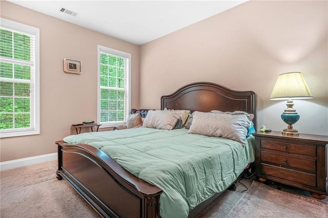 carpeted bedroom with baseboards, visible vents, and multiple windows