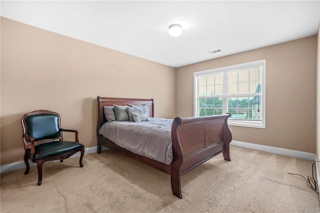 bedroom with baseboards, light carpet, and visible vents