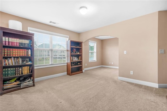 interior space with arched walkways, baseboards, and visible vents