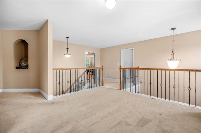 hallway with baseboards, carpet flooring, and an upstairs landing