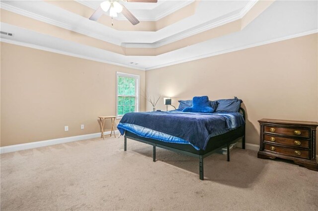 carpeted bedroom featuring crown molding, a raised ceiling, ceiling fan, and baseboards
