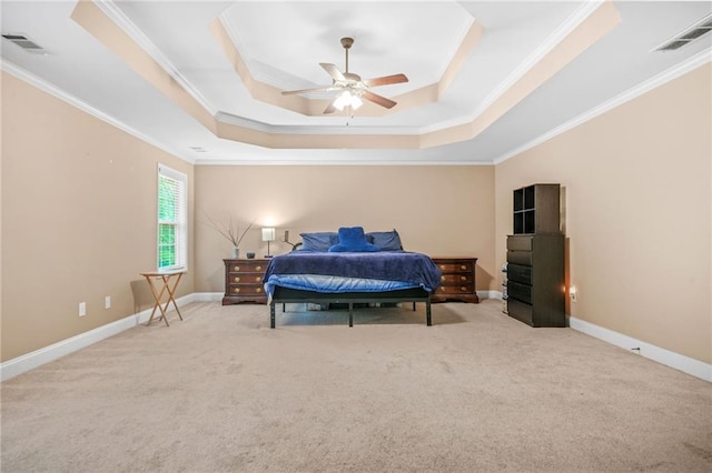 carpeted bedroom featuring crown molding, a tray ceiling, and visible vents