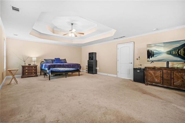 carpeted bedroom featuring visible vents, a raised ceiling, baseboards, and crown molding