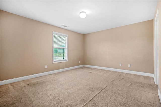 unfurnished room featuring visible vents, baseboards, and light carpet