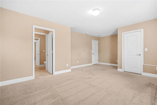 empty room with baseboards and light carpet