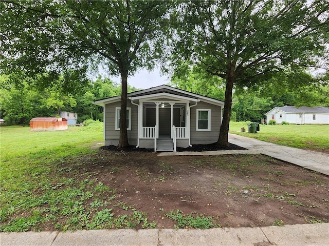 908 Davis St, Monroe, GA 30655 - bungalow-style home with a shed, a front lawn, a porch, and an outbuilding